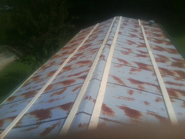 Rusted metal roof panels with new wood purlins before replacement — Storm Damage Roof Repair in New Columbia by Roofing Brothers