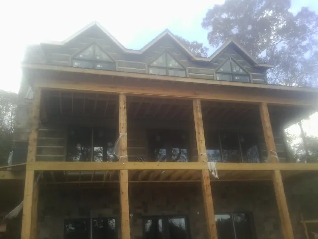 Dormers and porch framing on a large log home under construction — Roof Coating work by our crew in New Columbia