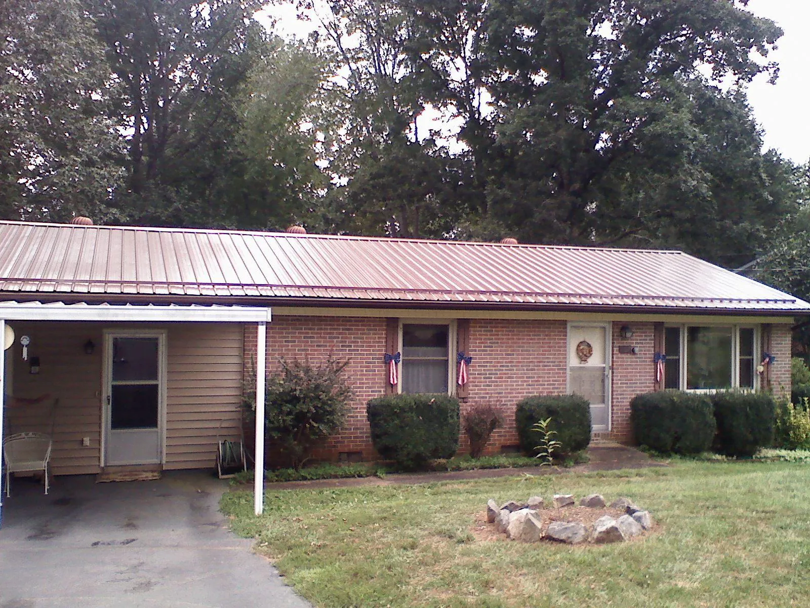 Bronze metal roof and carport on a brick ranch home — Roof Repair work by our crew in New Columbia
